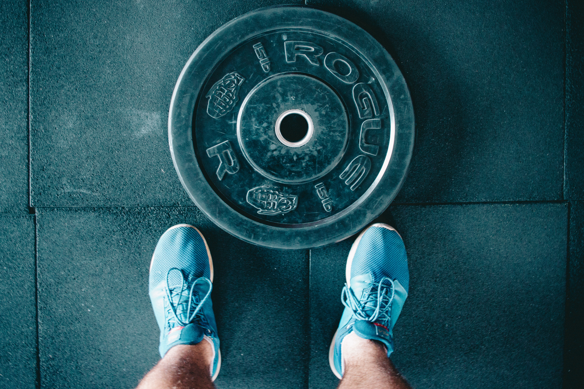 Black Steel Gym Plate and Pair of Blue Running Shoes
